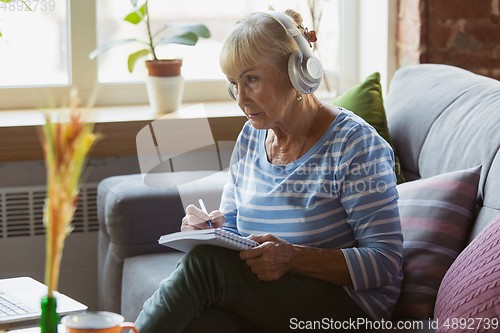 Image of Senior woman studying at home, getting online courses