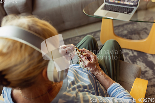 Image of Senior woman studying at home, getting online courses