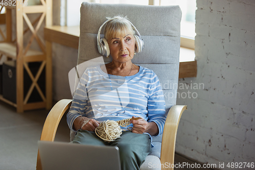 Image of Senior woman studying at home, getting online courses