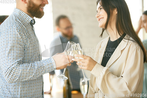 Image of People clinking glasses with wine or champagne. Happy cheerful friends celebrate holidays, meeting. Close up shot of smiling friends, lifestyle