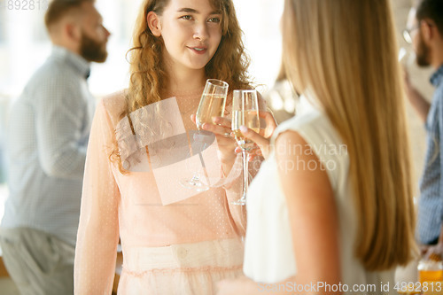 Image of People clinking glasses with wine or champagne. Happy cheerful friends celebrate holidays, meeting. Close up shot of smiling friends, lifestyle