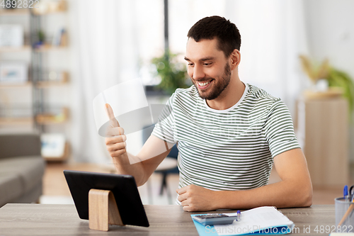 Image of man with tablet pc having video call at home