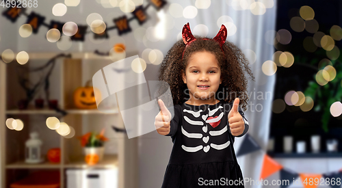 Image of girl in black dress and devil's horns on halloween