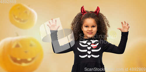 Image of girl in black dress and devil's horns on halloween