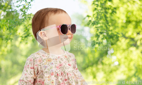 Image of happy little baby girl in sunglasses over nature