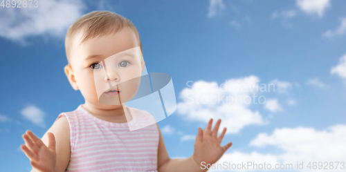 Image of portrait of little baby girl over blue sky