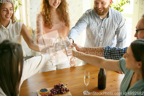 Image of People clinking glasses with wine or champagne. Happy cheerful friends celebrate holidays, meeting. Close up shot of smiling friends, lifestyle