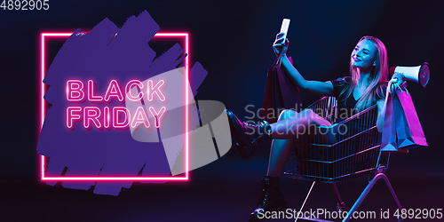 Image of Portrait of young woman in neon light on dark backgound. The human emotions, black friday, cyber monday, purchases, sales, finance concept. Neoned lettering.