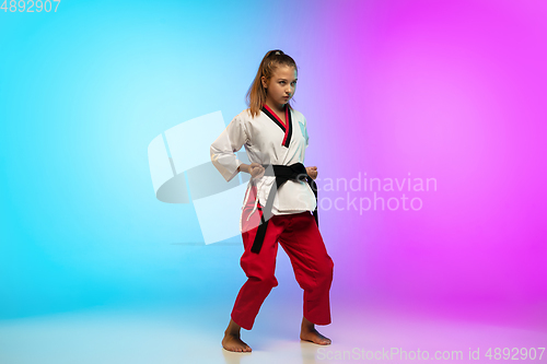 Image of Karate, taekwondo girl with black belt isolated on gradient background in neon light