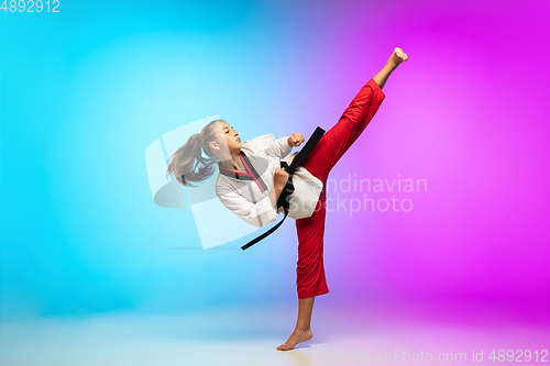 Image of Karate, taekwondo girl with black belt isolated on gradient background in neon light