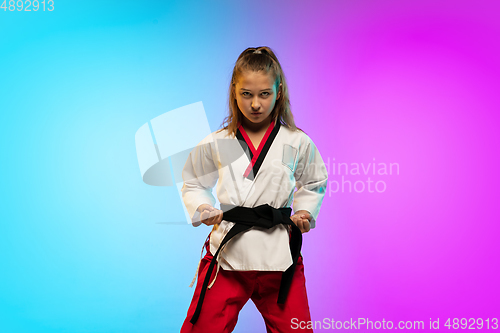 Image of Karate, taekwondo girl with black belt isolated on gradient background in neon light