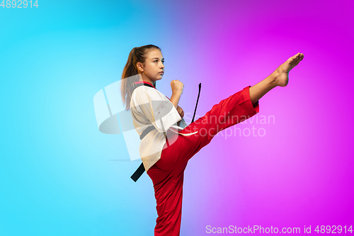 Image of Karate, taekwondo girl with black belt isolated on gradient background in neon light