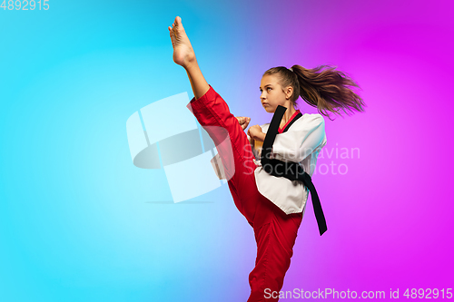 Image of Karate, taekwondo girl with black belt isolated on gradient background in neon light