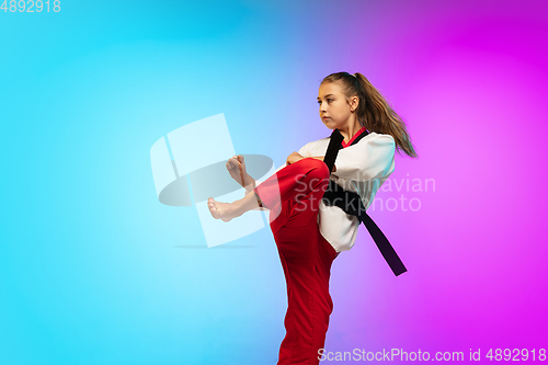 Image of Karate, taekwondo girl with black belt isolated on gradient background in neon light