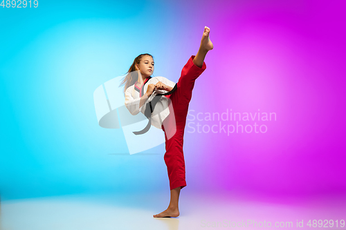 Image of Karate, taekwondo girl with black belt isolated on gradient background in neon light