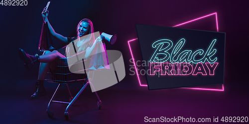 Image of Portrait of young woman in neon light on dark backgound. The human emotions, black friday, cyber monday, purchases, sales, finance concept. Neoned lettering.