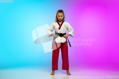 Image of Karate, taekwondo girl with black belt isolated on gradient background in neon light