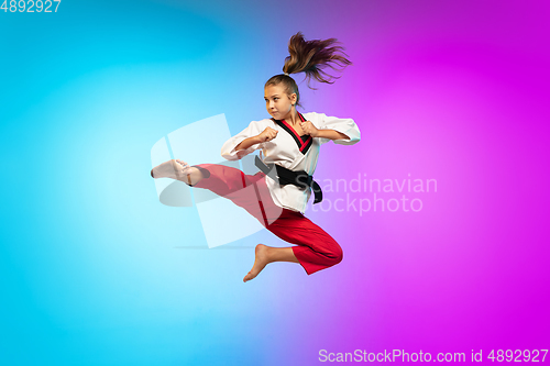 Image of Karate, taekwondo girl with black belt isolated on gradient background in neon light