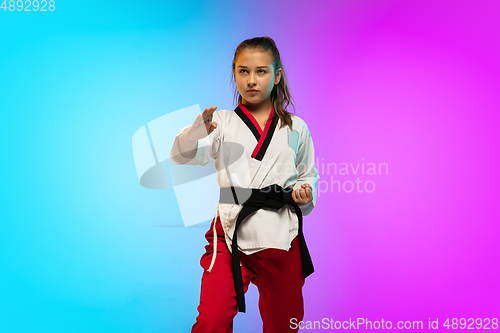 Image of Karate, taekwondo girl with black belt isolated on gradient background in neon light