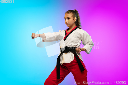 Image of Karate, taekwondo girl with black belt isolated on gradient background in neon light