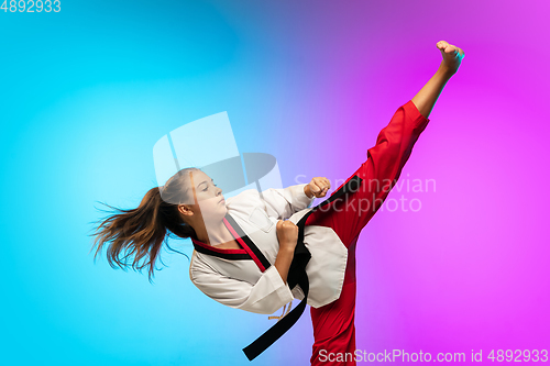 Image of Karate, taekwondo girl with black belt isolated on gradient background in neon light