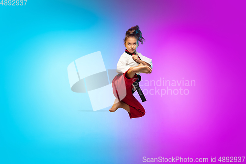 Image of Karate, taekwondo girl with black belt isolated on gradient background in neon light