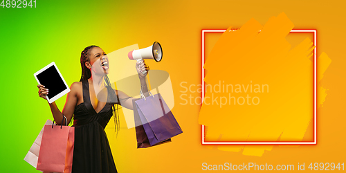 Image of Portrait of young woman in neon light on gradient backgound. The human emotions, black friday, cyber monday, purchases, sales, finance concept. Neoned lettering.