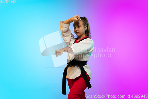 Image of Karate, taekwondo girl with black belt isolated on gradient background in neon light