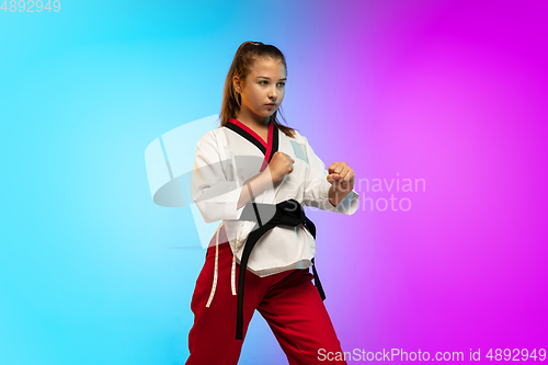 Image of Karate, taekwondo girl with black belt isolated on gradient background in neon light