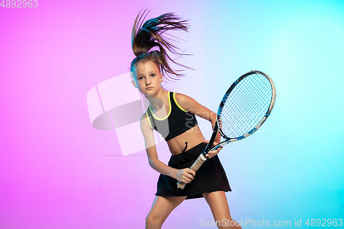 Image of Little tennis girl in black sportwear isolated on gradient background in neon light