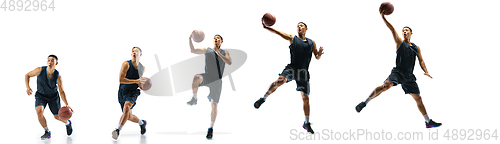 Image of Young basketball player against white studio background in motion of step-to-step goal