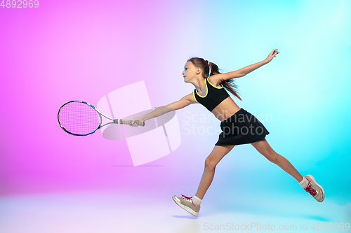 Image of Little tennis girl in black sportwear isolated on gradient background in neon light