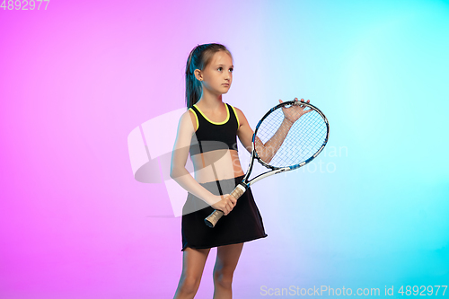 Image of Little tennis girl in black sportwear isolated on gradient background in neon light