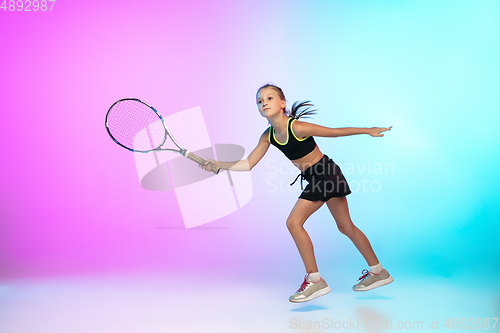 Image of Little tennis girl in black sportwear isolated on gradient background in neon light