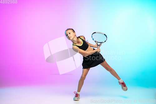 Image of Little tennis girl in black sportwear isolated on gradient background in neon light