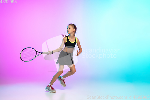 Image of Little tennis girl in black sportwear isolated on gradient background in neon light