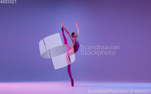Image of Young and graceful ballet dancer isolated on purple studio background in neon light