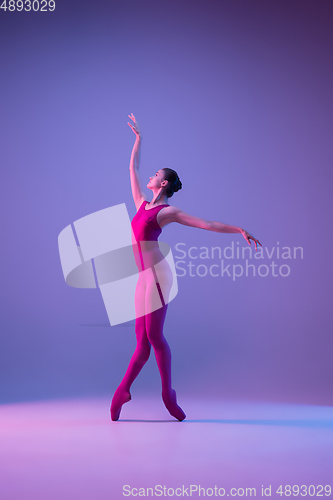 Image of Young and graceful ballet dancer isolated on purple studio background in neon light