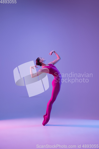 Image of Young and graceful ballet dancer isolated on purple studio background in neon light