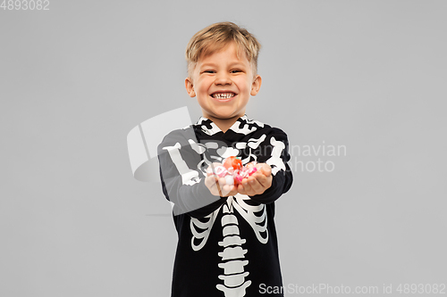 Image of boy with candies trick-or-treating on halloween