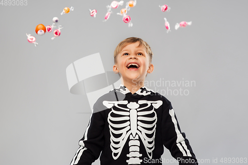 Image of boy with candies trick-or-treating on halloween