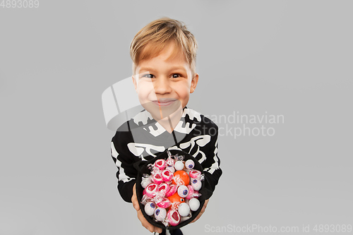 Image of boy with candies trick-or-treating on halloween