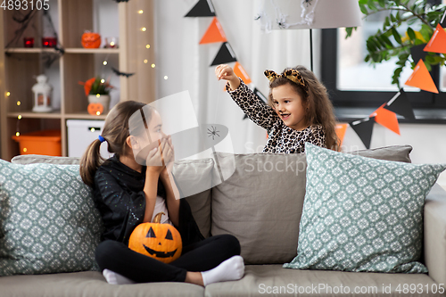 Image of girls in halloween costumes playing with spider