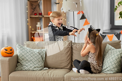 Image of kids in halloween costumes playing at home