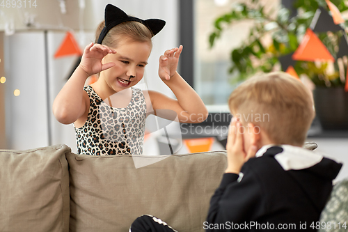 Image of kids in halloween costumes playing at home