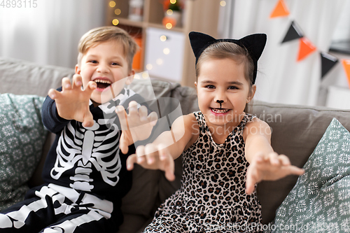 Image of kids in halloween costumes having fun at home