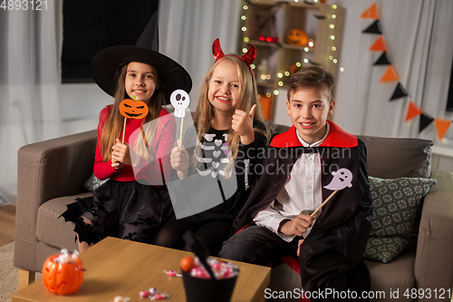 Image of kids in halloween costumes having fun at home