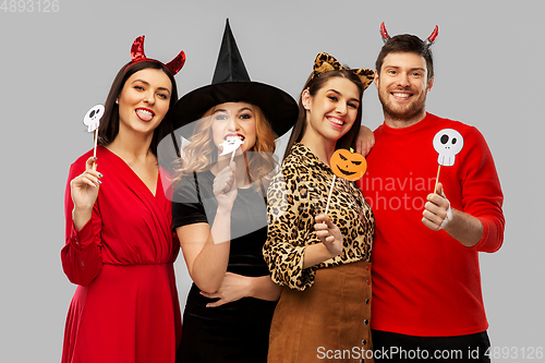 Image of friends in halloween costumes with party props
