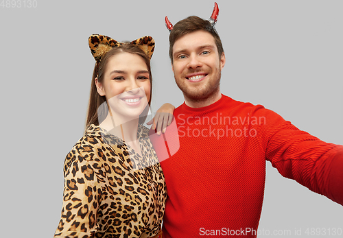 Image of happy couple in halloween costumes taking selfie