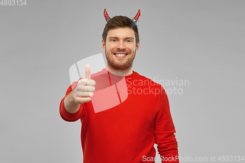 Image of happy man in costume of devil showing thumbs up